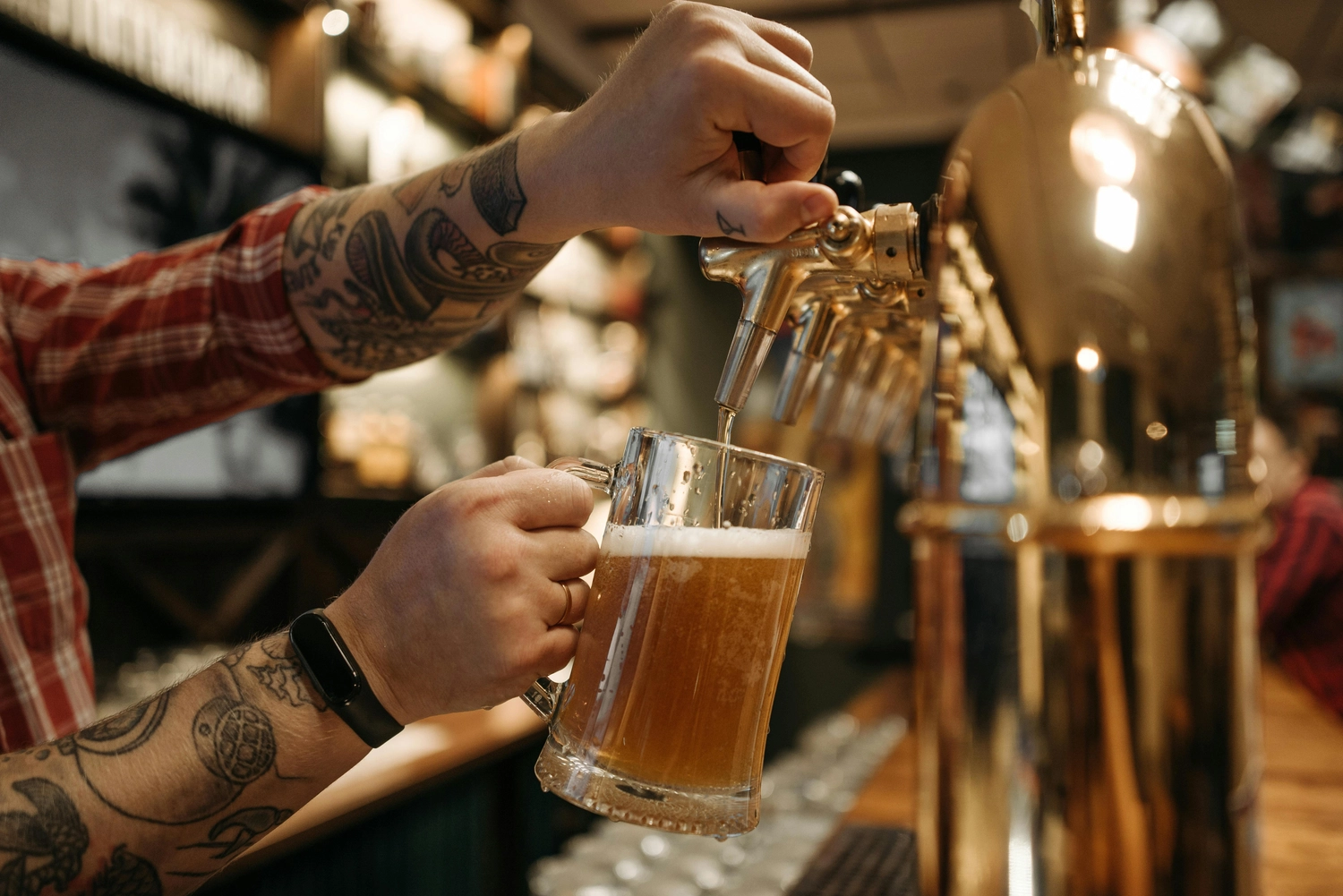 Hygge - Ferienwohnung - Dieses Bild fängt ein fröhliches Treffen von Freunden ein, die gemeinsam Bierflaschen anstoßen.